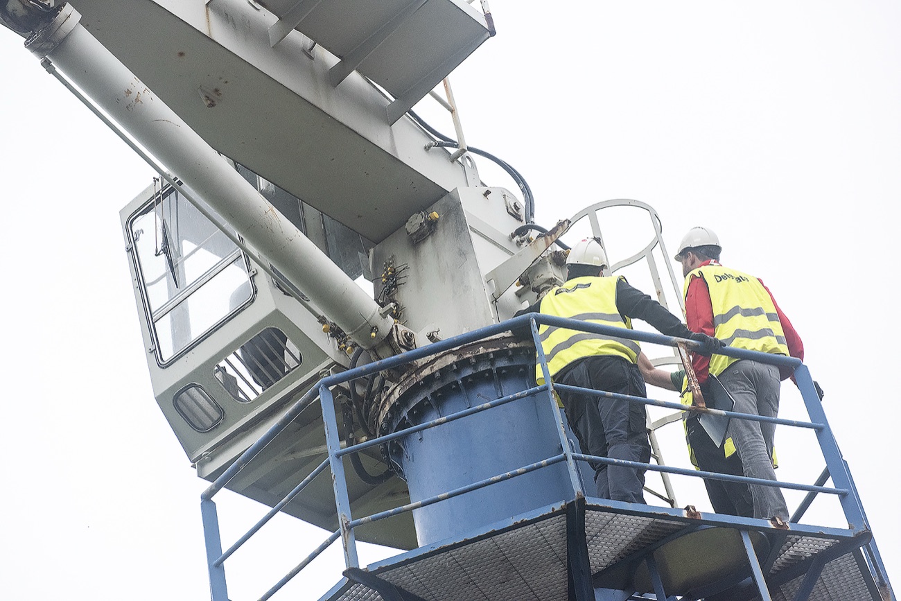 Two CRALOG inspectors examining a shipboard crane from its access platform